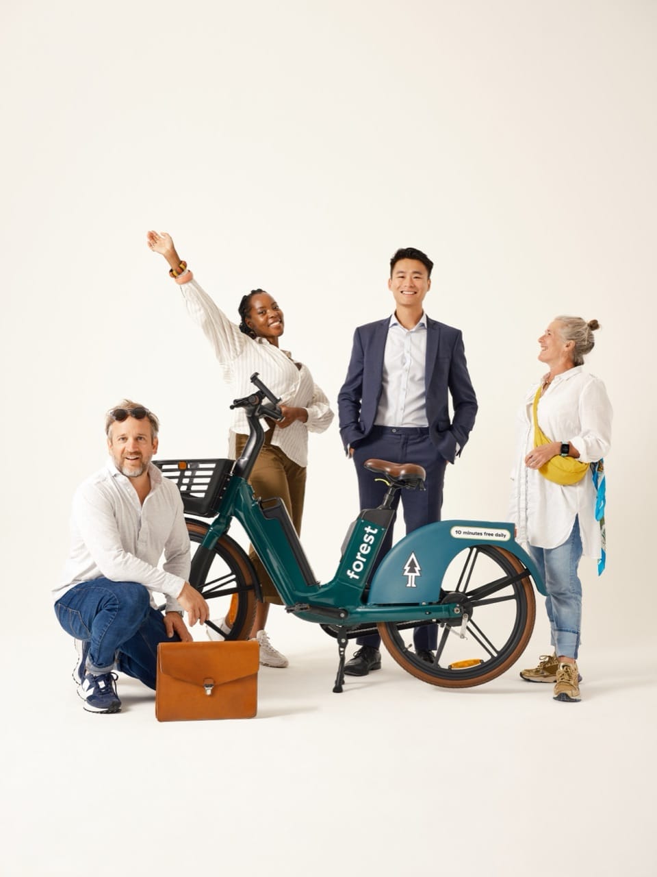 A group of people from different backgrounds standing together with a Forest shared bike.