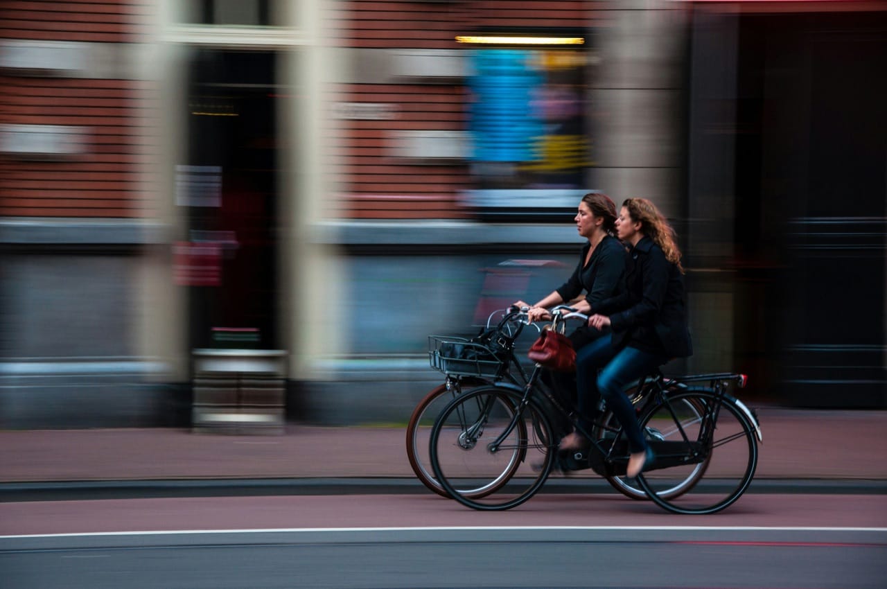 People cycling through a city street.